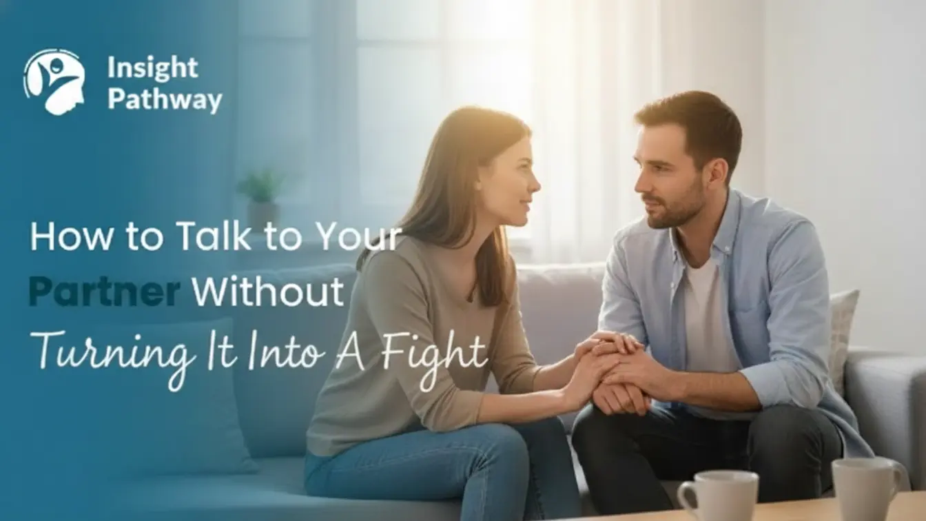 A couple sitting close on a sofa, holding hands and having a calm, supportive conversation in a bright living room, showing How to Talk to Your Partner with care and understanding.